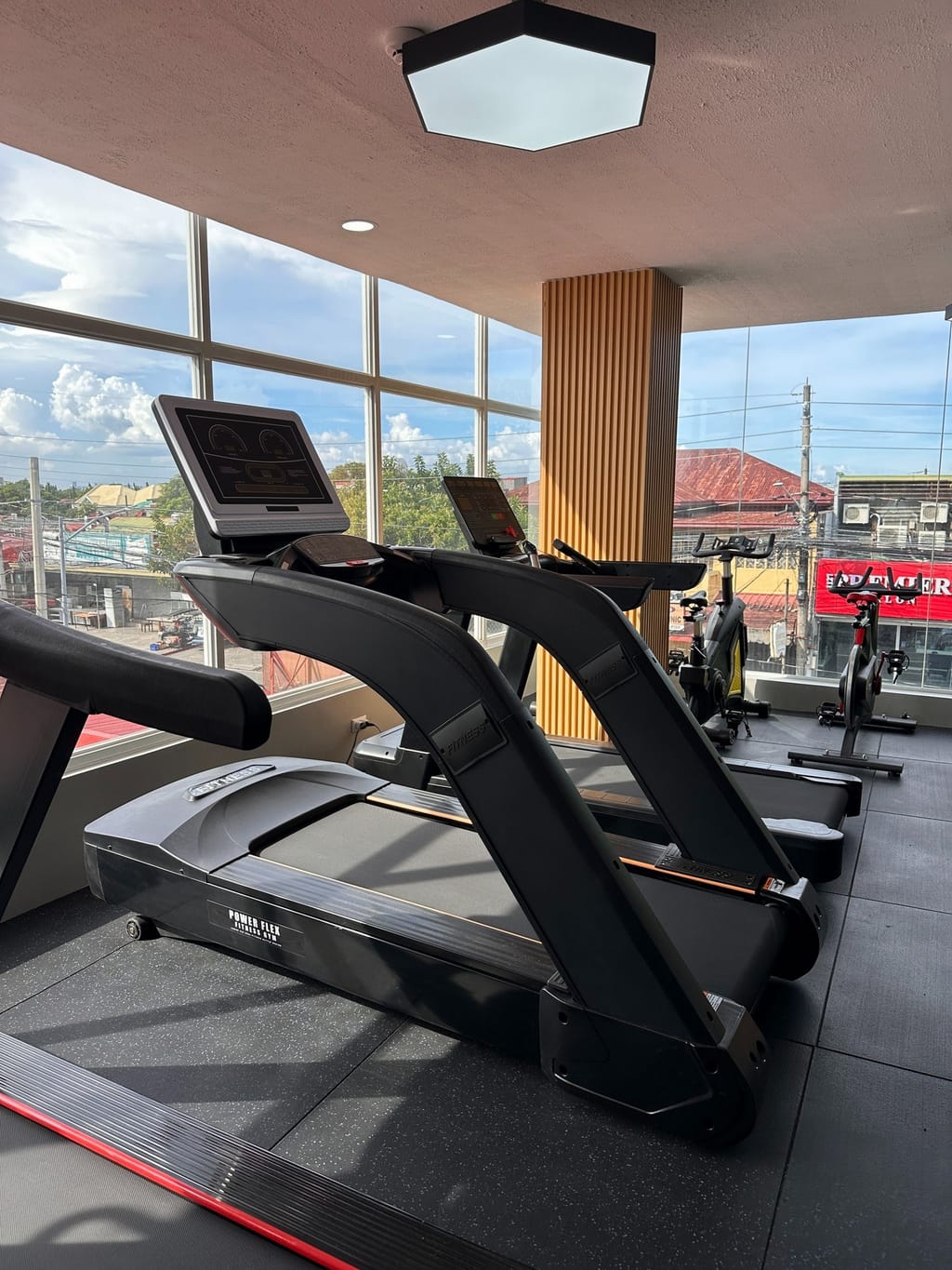 President's Ave. branch treadmills and spin bikes beside floor-to-ceiling windows overlooking the street