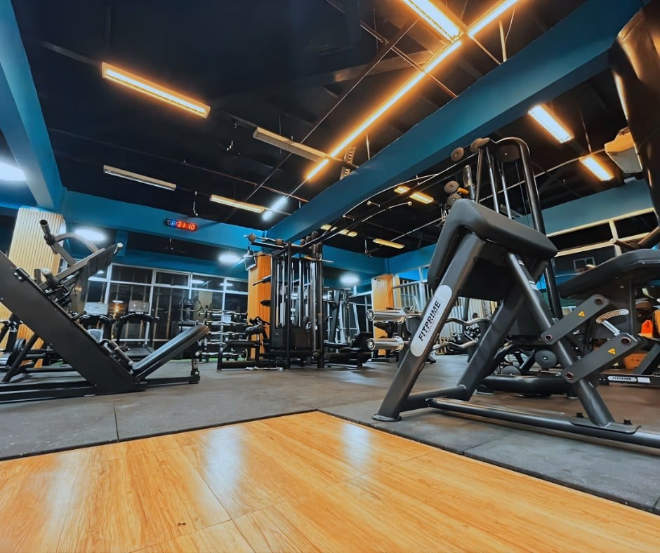 V. Luna Ave. branch strength floor with a preacher curl bench, a leg press and a cable machine under blue beams